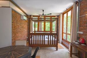a living room with a table and a brick wall at Ko Lake Villa in Ahangama