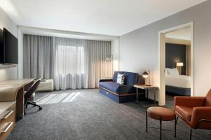 Courtyard by Marriott Redwood City في ريدوود سيتي: غرفة فندق مع أريكة وسرير