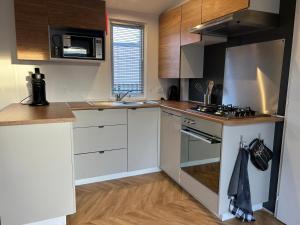 a kitchen with white cabinets and a stove top oven at Chalet Aventura 1-6 pers- 3 slaapk- 2 badk- Berging- Inchecken al vanaf 13 uur - incl gebruik koffie en thee in Lauwersoog