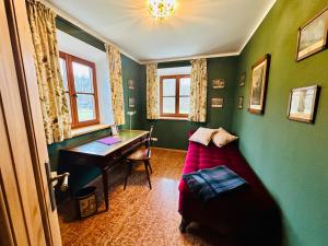 VILLA SEEBERG - by "Schloss Gessenberg" luxurious vacation home with lake and mountain views, suitable for families and friends في Petting: غرفة بها مكتب وأريكة وطاولة