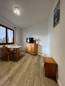 a living room with a table and a tv at Le Studio Louise Pratique & Central in Brides-les-Bains