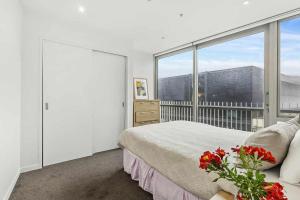 a bedroom with a bed and a large window at 3-Bedroom CBD Elevate Apartment in Wellington
