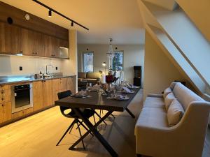 a living room and kitchen with a table and a couch at Åre Stay - Nybyggd Penthouse-lägenhet I Twintip in Åre