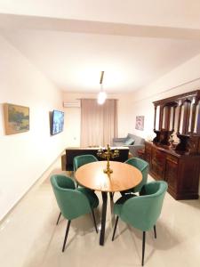 een woonkamer met een tafel en groene stoelen bij LUX Central in Alexandroupoli