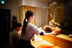 糸島市にある泊まる寿司屋一力 Sushi houseのキッチンでビデオゲームをしている女性