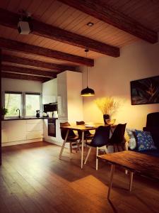 a living room with a dining table and a kitchen at Domek w Poleskim Parku in Urszulin