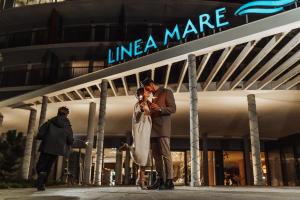 a man and a woman standing in front of a store at Hotel Linea Mare in Pobierowo