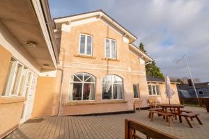 a building with tables and benches in front of it at Big Family Home Near Romo Spacious for 30 Guests in Skærbæk