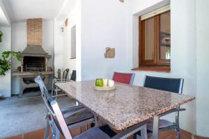 Una cocina con una mesa con sillas y una chimenea. en Hauzify I Vanessa Park, en El Casalot