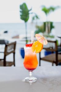 a drink sitting on a table with an orange drink at Blue Ocean Tofo Hotel & Resort in Inhambane