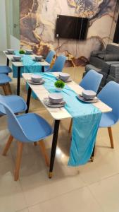 a group of tables with blue chairs and a screen at Tanglin Tower with Netfix by AquHome in Surabaya