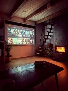 a large screen in a room with a table at Domek w Poleskim Parku in Urszulin