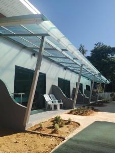 awning over a patio with chairs and tables at Naranta House in Ko Raeng