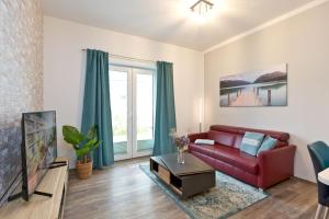 a living room with a red couch and a tv at Am Hafen 8 in Röbel
