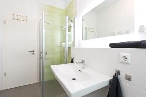a white bathroom with a sink and a shower at Am Hafen 8 in Röbel +4 photos
