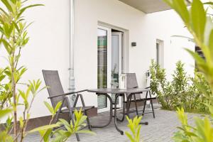 a table and chairs on a patio with plants at Am Hafen 8 in Röbel
