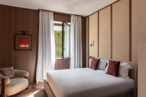 a bedroom with a white bed and a window at NAMAN HOTELLERIE - Roma in Rome