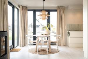 Un comedor con una mesa y sillas blancas. en Waterlodge in Heeg - Relax, sail and enjoy!, en Heeg 11 fotos más