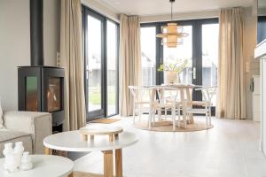 Una sala de estar con chimenea y una mesa y sillas. en Waterlodge in Heeg - Relax, sail and enjoy!, en Heeg