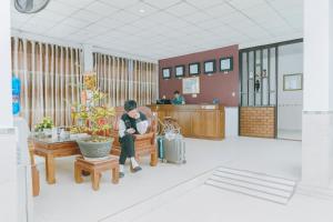 a man sitting on a chair in a waiting room at Bảo Ngọc Hotel Đông Hà in Quang Tri +8 photos