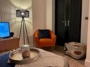 a living room with an orange chair and a table at Solihull Modern Living - 1 Bed Apartment in Solihull