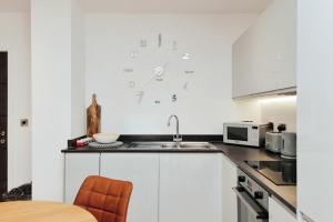 a kitchen with a sink and a clock on the wall at Solihull Modern Living - 1 Bed Apartment in Solihull
