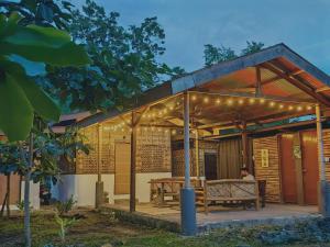 a house with a pergola with a bench and lights at Nipaville Haven in Moalboal