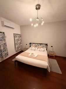 a bedroom with a large bed with a chandelier at La Corte Guesthouse in Cornate dʼAdda