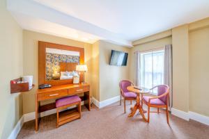 a hotel room with a desk and chairs and a table at The Gateway Hotel in Swinford