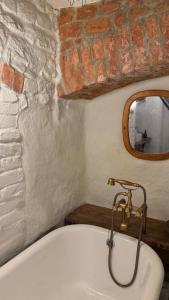 a bathroom with a bath tub and a mirror at Witch House Apartment in Rīga