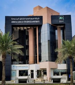 een gebouw met palmbomen ervoor bij Aswar Al olaya for serviced Apartments in Al Khobar