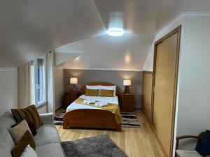 una camera da letto con un letto e un divano di Moniz Apartment a Caniço