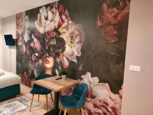 a room with a table and two chairs and a flower mural at AmaMolto Gardens in Wrocław
