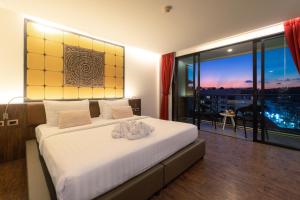 The Beach Residence Kata في شاطئ كاتا: غرفة نوم بسرير كبير ونافذة كبيرة