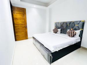 Un dormitorio con una cama con cabecero negro. en Hotel 24 Stay - Near Max Hospital, en Nueva Delhi