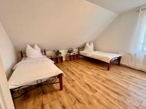 zwei Betten in einem Zimmer mit Holzboden in der Unterkunft Pamela in Eußenheim