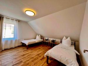 ein Zimmer mit zwei Betten und einem Fenster in der Unterkunft Pamela in Eußenheim