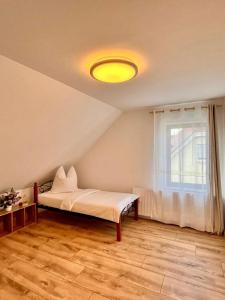 ein Schlafzimmer mit einem Bett und einem Fenster in einem Zimmer in der Unterkunft Pamela in Eußenheim