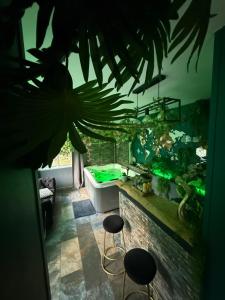 a room with a aquarium with stools and a tub at leverest rooms in Marseille