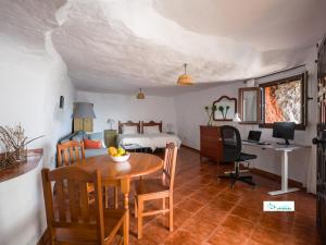 a room with a table and a bed and a desk at Living Artenara - CAVE HOUSE & SILENCE Adults Only in Artenara