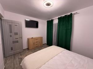 a bedroom with a bed and a green curtain at Casa Maxi in Gherla +5 photos