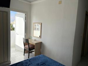 a bedroom with a bed and a desk with a chair at Hotel Amine in Sfax +27 photos
