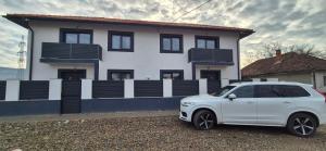 a white car parked in front of a house at Casa Maxi in Gherla