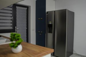 a kitchen with a stainless steel refrigerator and a table at Casa Maxi in Gherla
