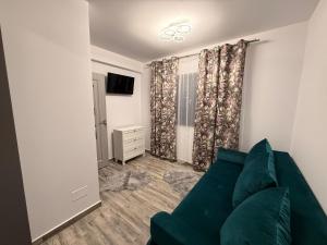 a living room with a green couch and a television at Casa Maxi in Gherla