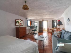 a bedroom and living room with a bed and a table at Living Artenara - CAVE HOUSE & SILENCE Adults Only in Artenara