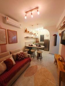 uma sala de estar com um sofá e uma cozinha em Solar Águas Pipa Stays em Pipa