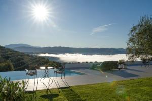 a pool with chairs and a view of the mountains at Villa with Private Pool & Lake View near Motovun, Casa Mille Olivi Heritage in Buzet