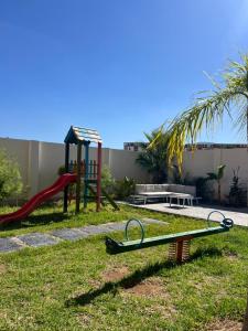a playground with a slide and a swing set at Résidence Guebbas in Skikda +3 photos