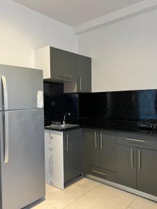 a kitchen with a stainless steel refrigerator and gray cabinets at Résidence Guebbas in Skikda